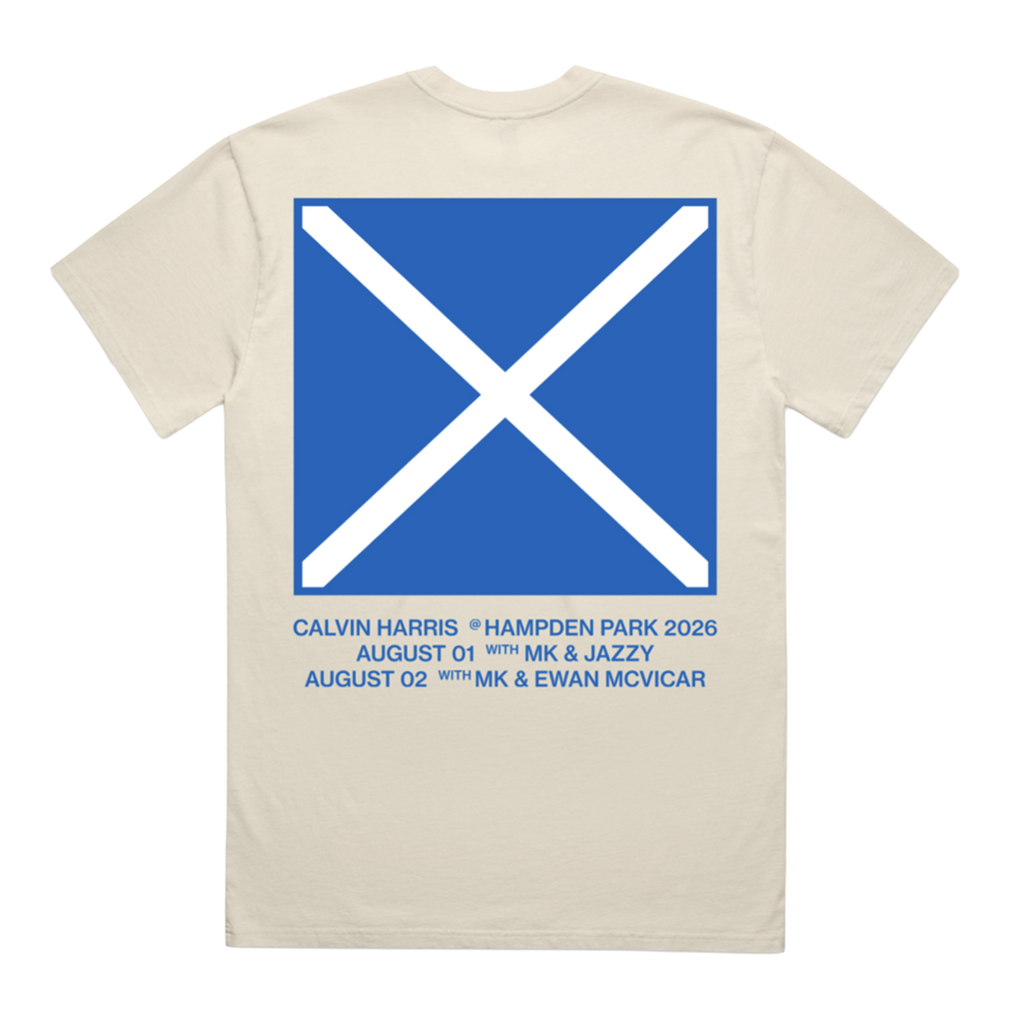 A cream-colored short-sleeve t-shirt shown from the back, featuring a large blue square graphic with a white diagonal cross, resembling the Scottish flag. Below the graphic, blue text lists concert dates and names: Calvin Harris, Hampden Park 2026, August 1st with MK & Jazzy, and August 2nd with Ewan Mcvicar.