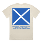 A cream-colored short-sleeve t-shirt shown from the back, featuring a large blue square graphic with a white diagonal cross, resembling the Scottish flag. Below the graphic, blue text lists concert dates and names: Calvin Harris, Hampden Park 2026, August 1st with MK & Jazzy, and August 2nd with Ewan Mcvicar.